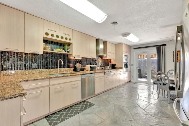 501 SE 7th Ave, Pompano Beach, FL 33060 - kitchen with appliances with stainless steel finishes, wall chimney exhaust hood, cream cabinetry, a textured ceiling, and decorative backsplash