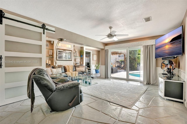 501 SE 7th Ave, Pompano Beach, FL 33060 - living area with a textured ceiling, a barn door, a ceiling fan, and built in features
