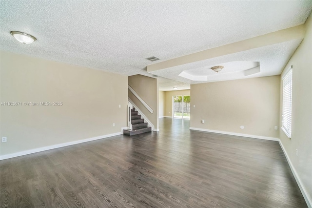 8995 SW 213th St, Cutler Bay, FL 33189 - unfurnished living room featuring a textured ceiling, stairway, dark wood finished floors, and a raised ceiling