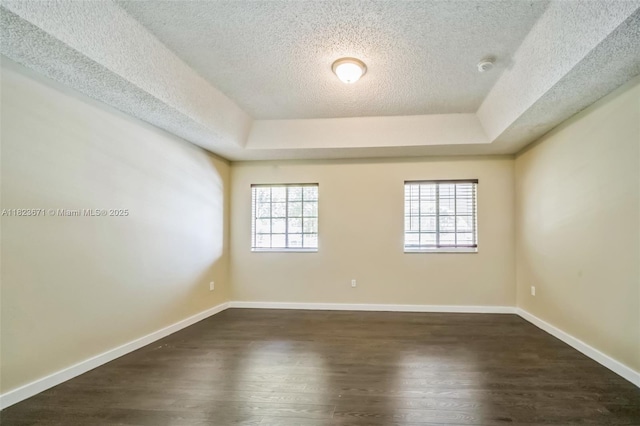 8995 SW 213th St, Cutler Bay, FL 33189 - spare room featuring a textured ceiling, a raised ceiling, dark wood-style flooring, and a smoke detector