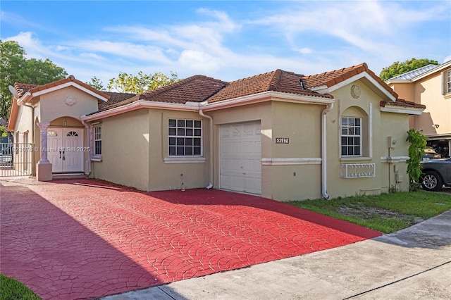 9537 SW 154th Ave, Miami, FL 33196 - mediterranean / spanish home featuring an attached garage, stucco siding, decorative driveway, a gate, and a tiled roof