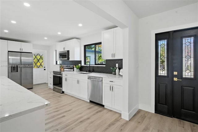 1157 SW 4th Ave, Pompano Beach, FL 33060 - kitchen with stainless steel appliances, light wood-style floors, tasteful backsplash, light stone countertops, and recessed lighting