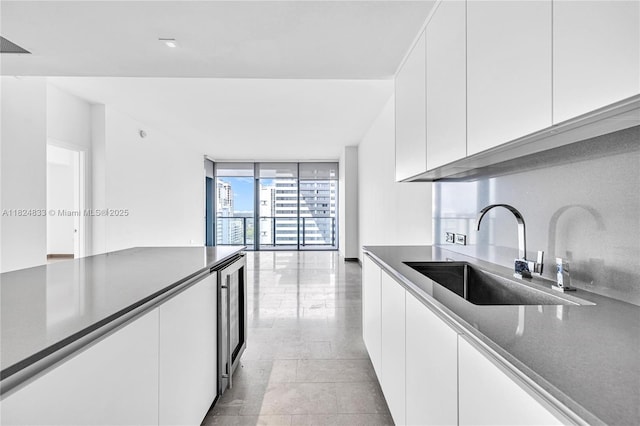88 SW 7th St Unit 1006, Miami, FL 33130 - kitchen featuring a wall of windows, white cabinetry, beverage cooler, modern cabinets, and light tile patterned floors
