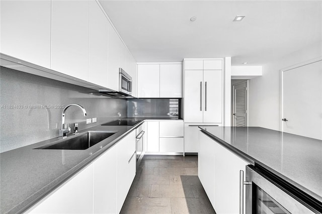 88 SW 7th St Unit 1006, Miami, FL 33130 - kitchen with beverage cooler, stainless steel microwave, black electric stovetop, tasteful backsplash, and white cabinets