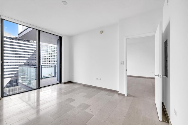 88 SW 7th St Unit 1006, Miami, FL 33130 - spare room with a wall of windows and baseboards