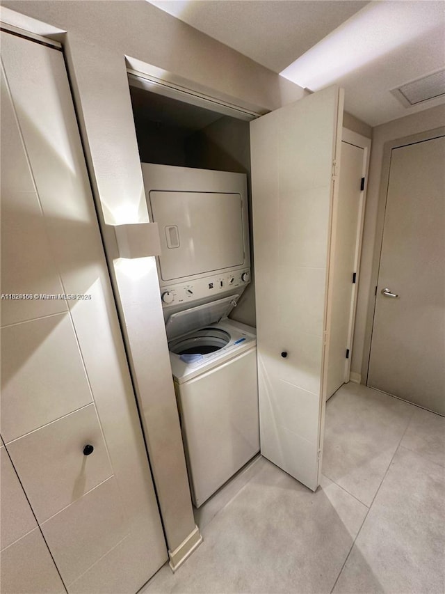 1010 SW 2nd Ave Unit 601, Miami, FL 33130 - washroom with stacked washing machine and dryer and light tile patterned flooring