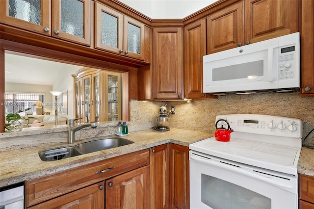 7121 Mimosa Way, Tamarac, FL 33321 - kitchen featuring white appliances, glass insert cabinets, light stone counters, brown cabinets, and backsplash