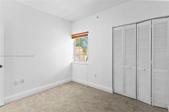6445 SW 130th Pl Unit 612, Miami, FL 33183 - unfurnished bedroom featuring carpet, a textured ceiling, and a closet