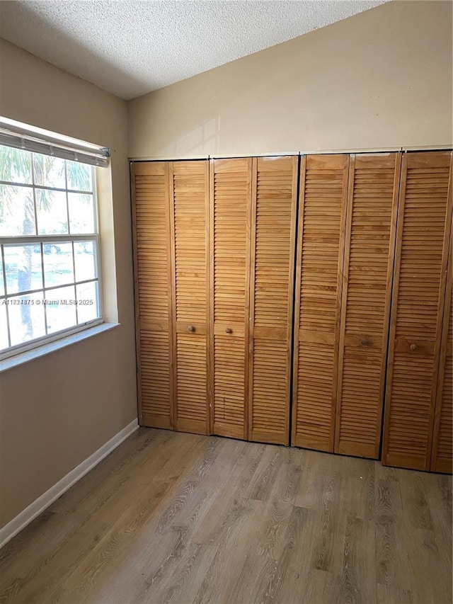 2113 Champions Unit 2113, North Lauderdale, FL 33068 - unfurnished bedroom featuring wood finished floors, a textured ceiling, and a closet
