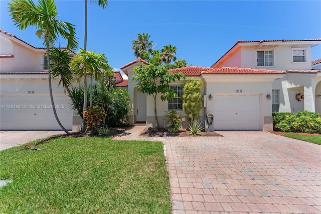 18739 SW 28th St, Miramar, FL 33029 - mediterranean / spanish-style house with stucco siding, decorative driveway, a tiled roof, a garage, and a front lawn