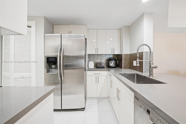 701 Brickell Key Blvd Unit 1605, Miami, FL 33131 - kitchen with appliances with stainless steel finishes, light tile patterned floors, tasteful backsplash, white cabinetry, and light countertops
