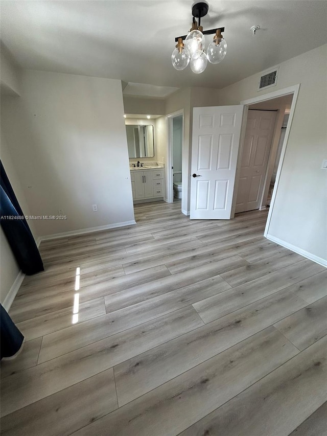 2921 NE 185th St Unit 1205, Aventura, FL 33180 - unfurnished bedroom featuring a chandelier, light wood finished floors, and ensuite bathroom