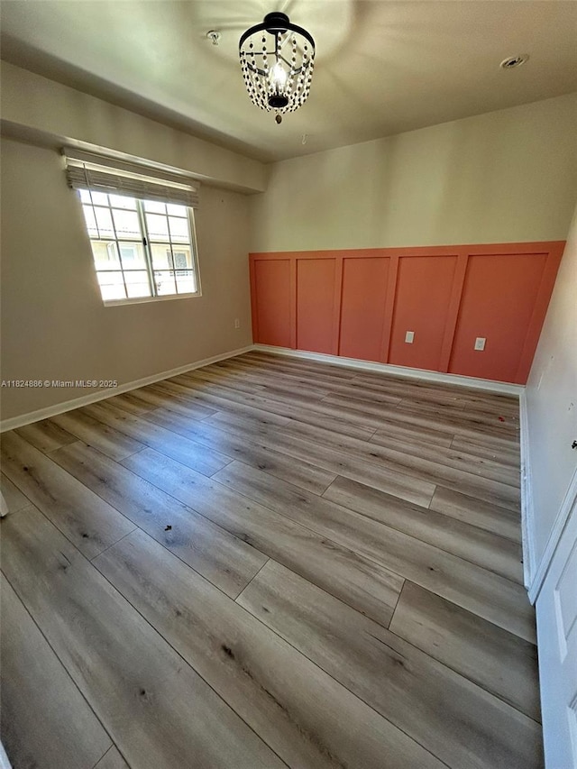2921 NE 185th St Unit 1205, Aventura, FL 33180 - unfurnished room with a chandelier, wood finished floors, and a decorative wall