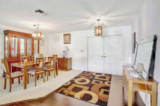 1600 SW 72nd Ave, Plantation, FL 33317 - dining area featuring a chandelier, wood finished floors, and a textured ceiling