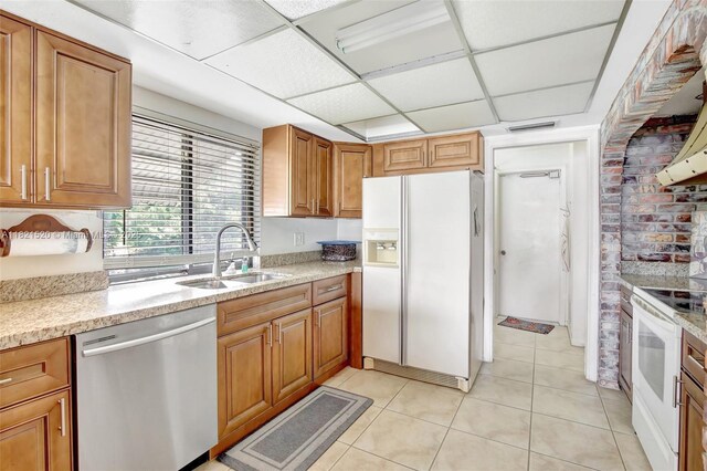 1600 SW 72nd Ave, Plantation, FL 33317 - kitchen with white appliances, light tile patterned floors, brown cabinets, light stone counters, and a drop ceiling