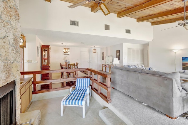 1600 SW 72nd Ave, Plantation, FL 33317 - living room with a ceiling fan, a wooden ceiling with exposed beams, a towering ceiling, light carpet, and a fireplace with flush hearth