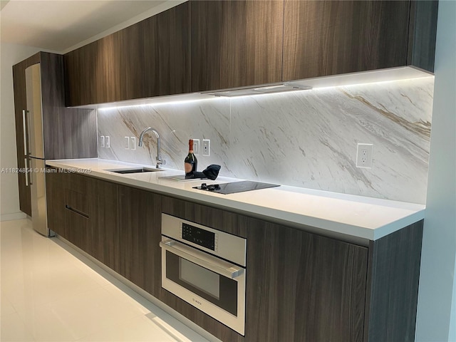 851 NE 1st Ave Unit 503, Miami, FL 33132 - kitchen with modern cabinets, decorative backsplash, oven, and light countertops