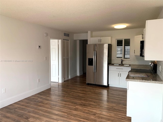 1250 NE 125th St Unit 410C, North Miami, FL 33161 - kitchen with appliances with stainless steel finishes, dark wood-style floors, a textured ceiling, decorative backsplash, and white cabinets