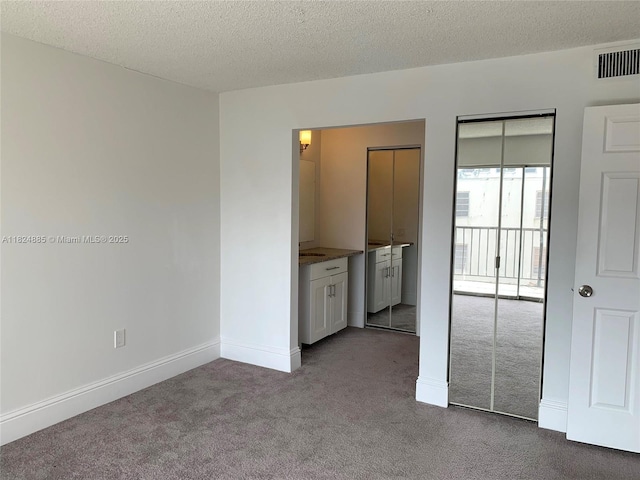 1250 NE 125th St Unit 410C, North Miami, FL 33161 - unfurnished bedroom with carpet floors and a textured ceiling