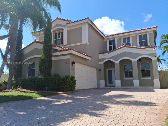 3610 SW 167th Ter, Miramar, FL 33027 - mediterranean / spanish house featuring an attached garage, stucco siding, a tile roof, and decorative driveway
