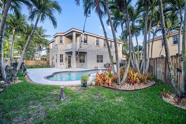 3610 SW 167th Ter, Miramar, FL 33027 - rear view of house with a balcony, stucco siding, a fenced backyard, a patio area, and a tiled roof