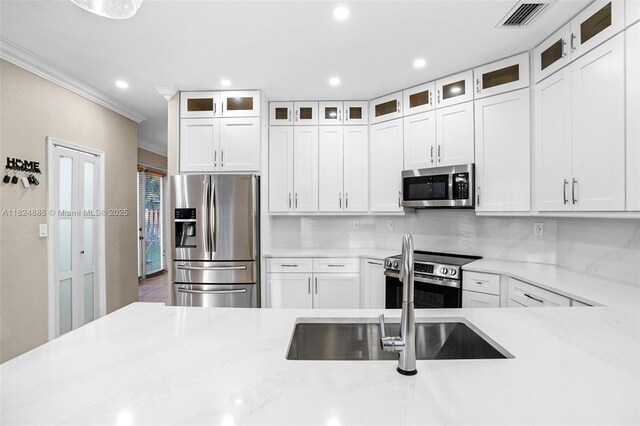 3610 SW 167th Ter, Miramar, FL 33027 - kitchen featuring appliances with stainless steel finishes, ornamental molding, white cabinets, recessed lighting, and light stone counters