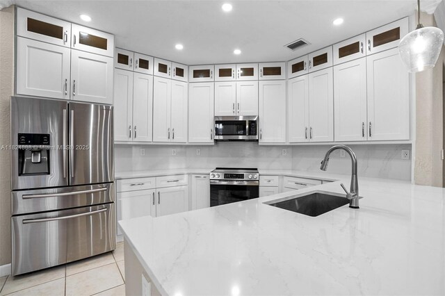 3610 SW 167th Ter, Miramar, FL 33027 - kitchen featuring stainless steel appliances, light stone counters, white cabinetry, light tile patterned flooring, and recessed lighting