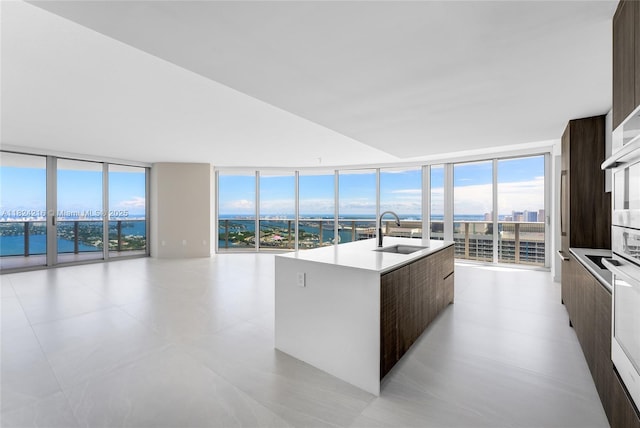 488 NE 18th St Unit 4112, Miami, FL 33132 - kitchen featuring modern cabinets, expansive windows, dark brown cabinets, an island with sink, and light countertops