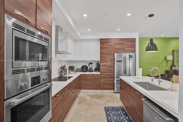 718 Valencia Ave Unit 204, Coral Gables, FL 33134 - kitchen featuring stainless steel appliances, wall chimney exhaust hood, modern cabinets, hanging light fixtures, and light countertops