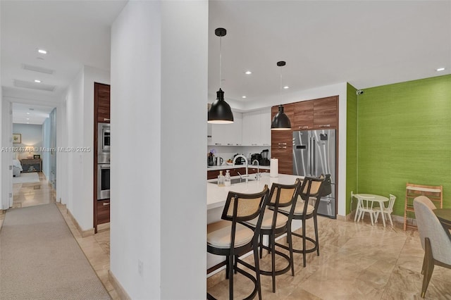 718 Valencia Ave Unit 204, Coral Gables, FL 33134 - kitchen featuring stainless steel appliances, light countertops, modern cabinets, recessed lighting, and a kitchen breakfast bar