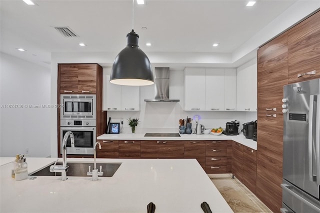 718 Valencia Ave Unit 204, Coral Gables, FL 33134 - kitchen featuring appliances with stainless steel finishes, wall chimney exhaust hood, modern cabinets, light countertops, and brown cabinetry