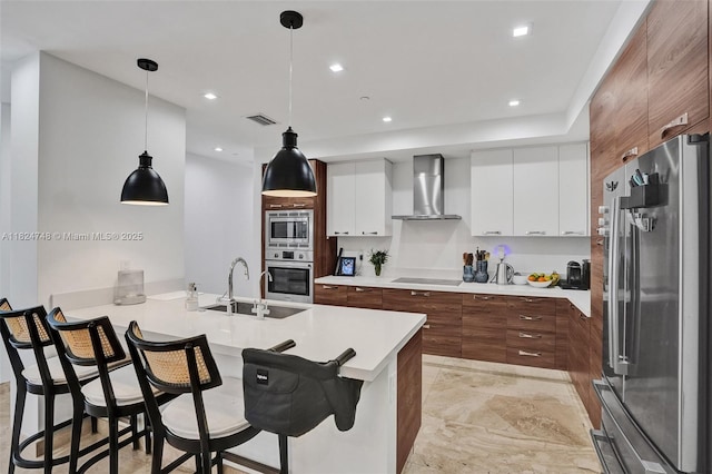 718 Valencia Ave Unit 204, Coral Gables, FL 33134 - kitchen featuring stainless steel appliances, wall chimney exhaust hood, a peninsula, modern cabinets, and a kitchen breakfast bar