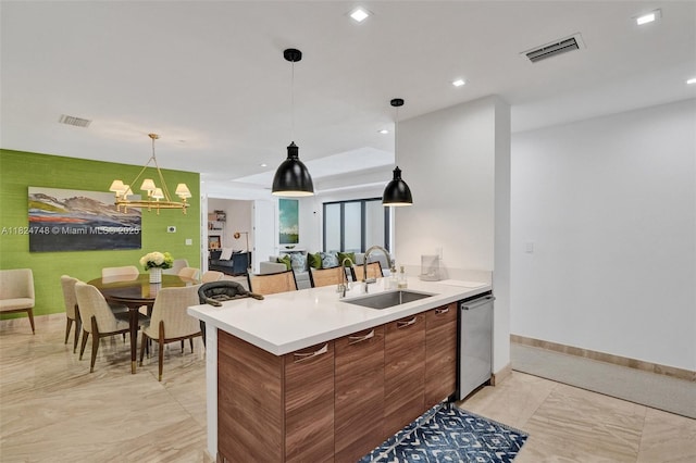 718 Valencia Ave Unit 204, Coral Gables, FL 33134 - kitchen featuring brown cabinets, dishwasher, light countertops, pendant lighting, and light marble finish floors