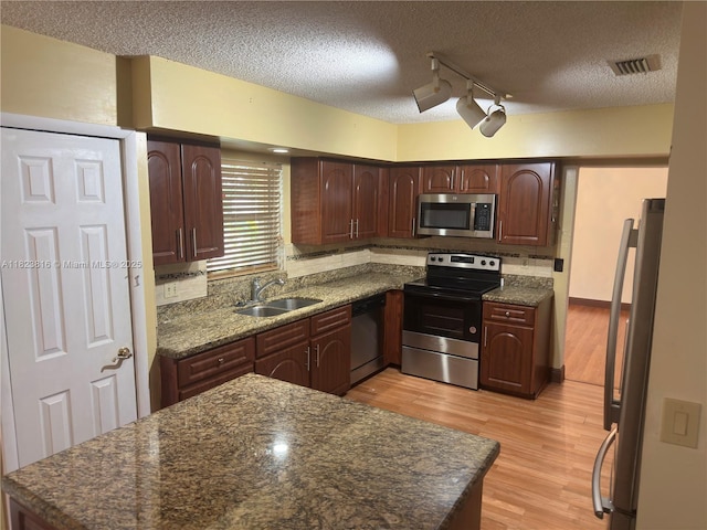 2660 Huron Way, Miramar, FL 33025 - kitchen featuring stainless steel appliances, light wood-style flooring, a textured ceiling, rail lighting, and decorative backsplash