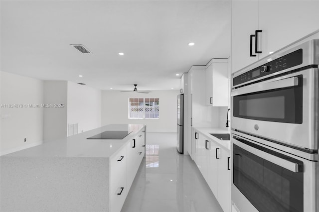 7441 NW 38th Ct, Lauderhill, FL 33319 - kitchen featuring appliances with stainless steel finishes, modern cabinets, white cabinetry, a ceiling fan, and recessed lighting