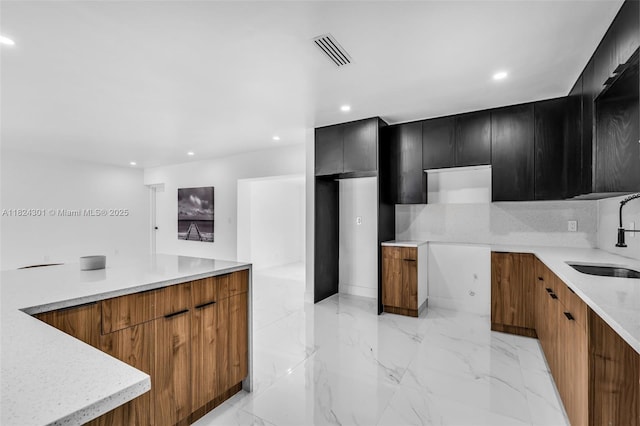 4660 W 8th Pl, Hialeah, FL 33012 - kitchen with modern cabinets, dark cabinetry, recessed lighting, light marble finish flooring, and brown cabinets