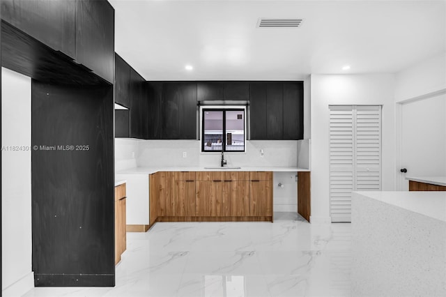 4660 W 8th Pl, Hialeah, FL 33012 - kitchen with dark cabinets, recessed lighting, modern cabinets, and light marble finish flooring