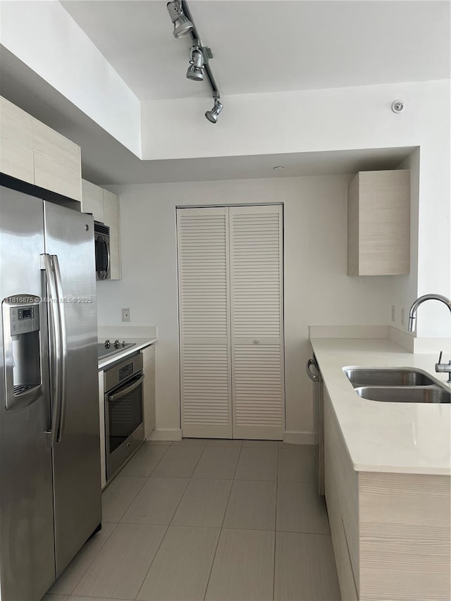 4250 Biscayne Blvd Unit 1618, Miami, FL 33137 - kitchen featuring appliances with stainless steel finishes, light countertops, track lighting, light tile patterned floors, and modern cabinets