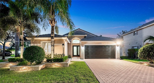 14295 NW 18th Pl, Pembroke Pines, FL 33028 - view of front facade with a garage, driveway, stucco siding, and a yard