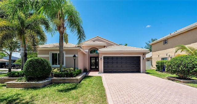 14295 NW 18th Pl, Pembroke Pines, FL 33028 - mediterranean / spanish-style home with a garage, stucco siding, decorative driveway, and a tile roof