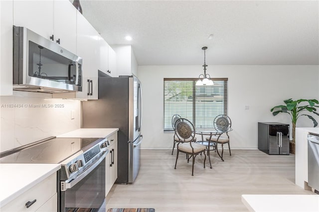 14295 NW 18th Pl, Pembroke Pines, FL 33028 - kitchen featuring stainless steel appliances, light wood-style flooring, light countertops, white cabinets, and recessed lighting