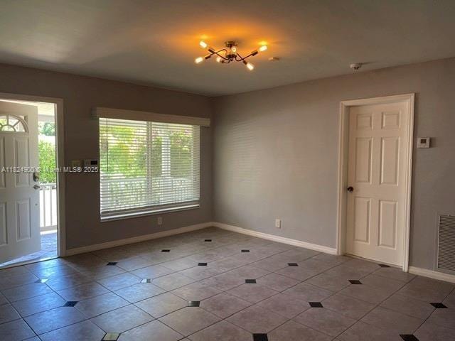 5433 NE 5th Ave, Oakland Park, FL 33334 - tiled empty room with baseboards and a chandelier