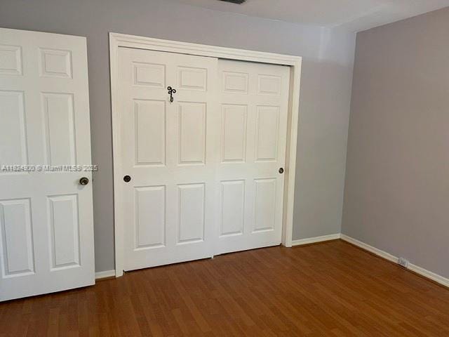 5433 NE 5th Ave, Oakland Park, FL 33334 - unfurnished bedroom featuring dark wood finished floors and a closet