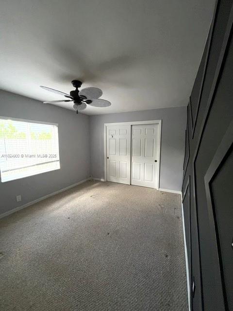 5433 NE 5th Ave, Oakland Park, FL 33334 - unfurnished bedroom with carpet floors, a closet, and a ceiling fan