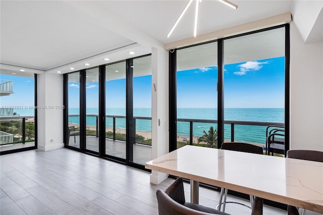 9455 Collins Ave Unit 809, Surfside, FL 33154 - dining room with expansive windows, a water view, plenty of natural light, recessed lighting, and wood finished floors