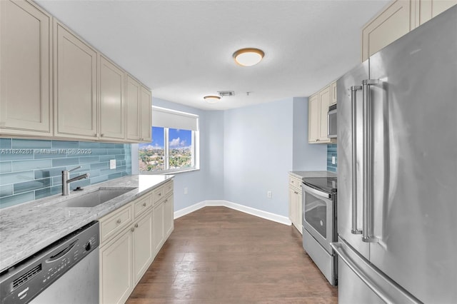 280 SW 20th Rd Unit 904, Miami, FL 33129 - kitchen with appliances with stainless steel finishes, tasteful backsplash, dark wood-type flooring, light stone countertops, and cream cabinets