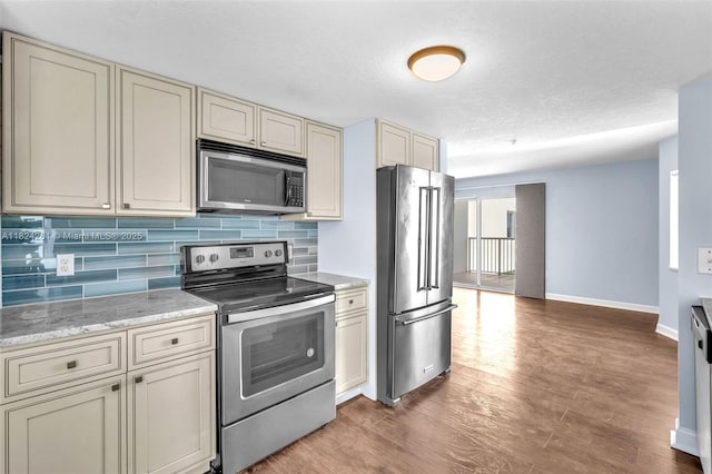 280 SW 20th Rd Unit 904, Miami, FL 33129 - kitchen with appliances with stainless steel finishes, cream cabinetry, backsplash, and light wood-type flooring