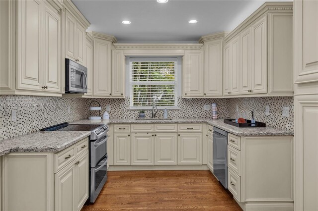 433 NE 91st St, Miami Shores, FL 33138 - kitchen with stainless steel appliances, light wood-style floors, backsplash, light stone countertops, and recessed lighting