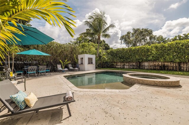 433 NE 91st St, Miami Shores, FL 33138 - view of pool featuring a patio, a fenced backyard, a pool with connected hot tub, and a storage unit