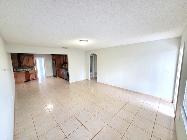 1800 SW 97th Ave, Miramar, FL 33025 - empty room featuring arched walkways, light tile patterned floors, and a textured ceiling